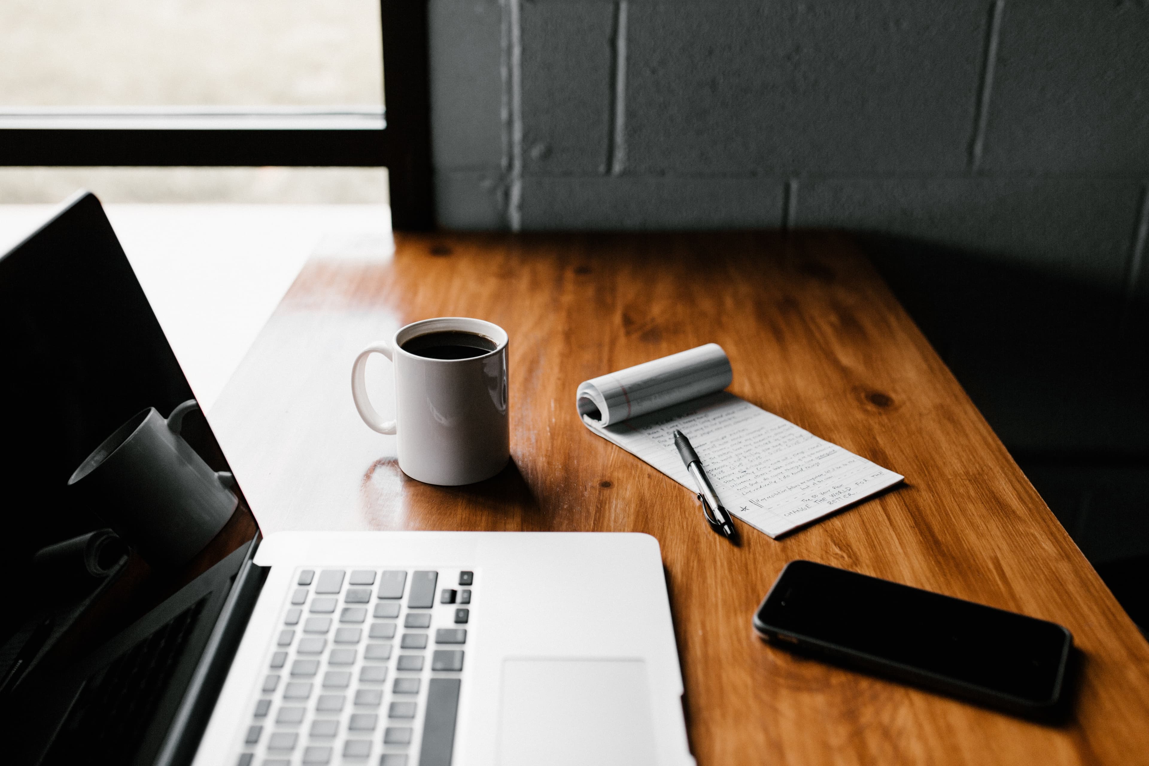 Laptop, phone and notepad at desk